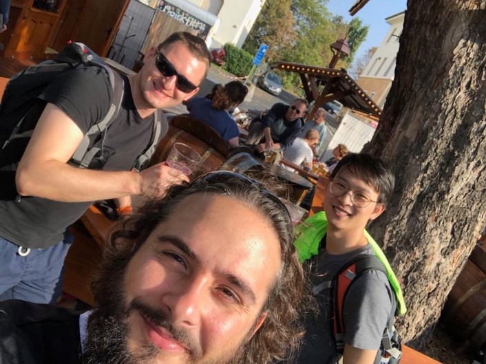 A group of people smiling in front of a crowd
Description automatically generated