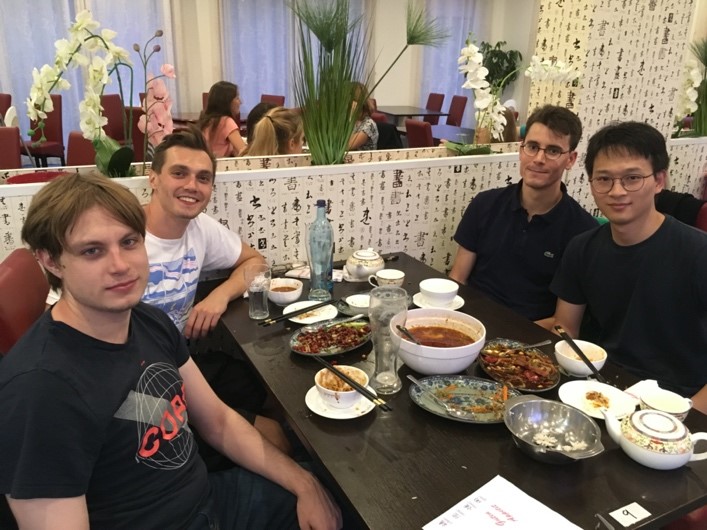 A group of people sitting at a table eating food
Description automatically generated